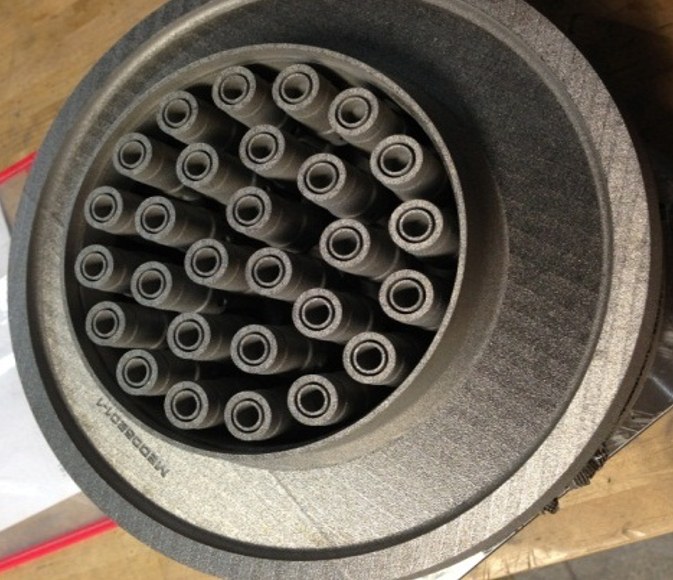 Looking down into an additively manufactured injector: a round housing packed with rows of hollow tubular elements.