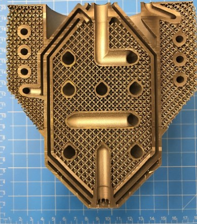 A sectioned additively manufactured part exposing internal channels inside a dense lattice structure.