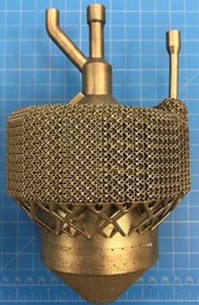 An additively manufactured component wrapped in an open lattice, with three feed tubes rising from the top.